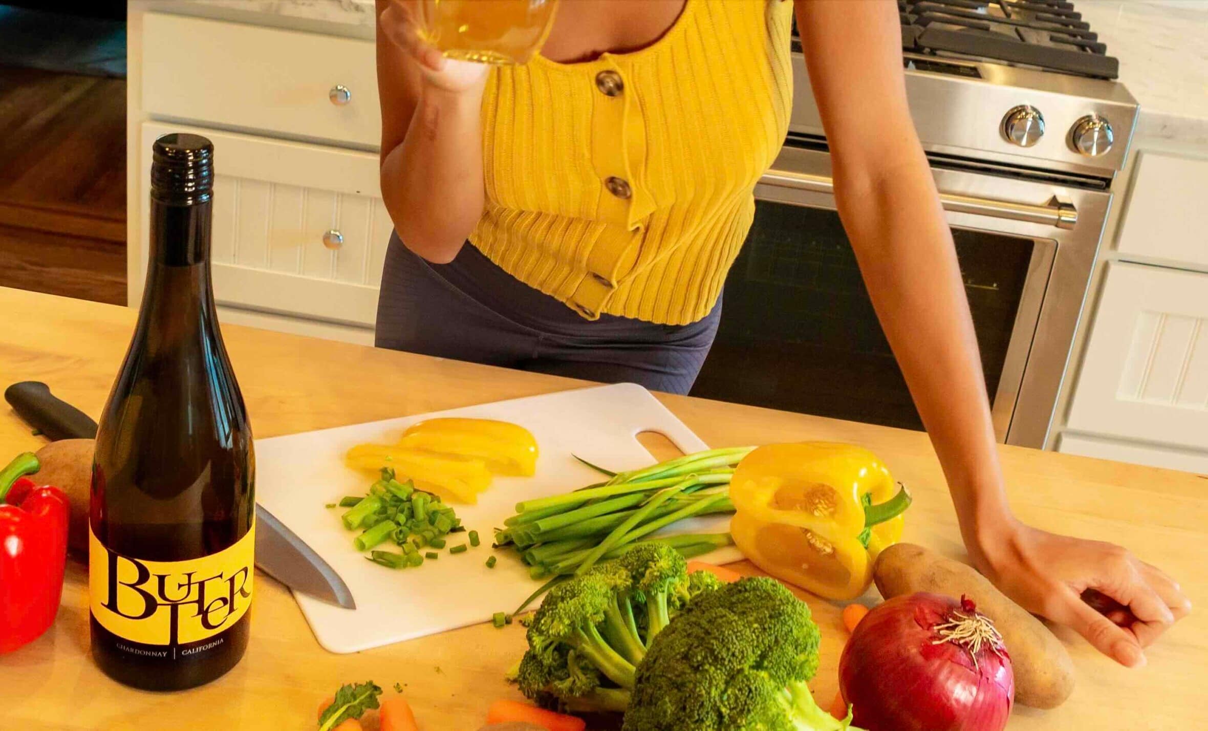 Cooking with Butter wine! Butter babe sipping on Butter Chardonnay while cutting vegetables in her kitchen.