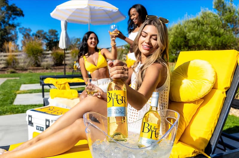 NEW Butter Sauv Blanc being pulled out of an ice bucket by the pool to enjoy with friends