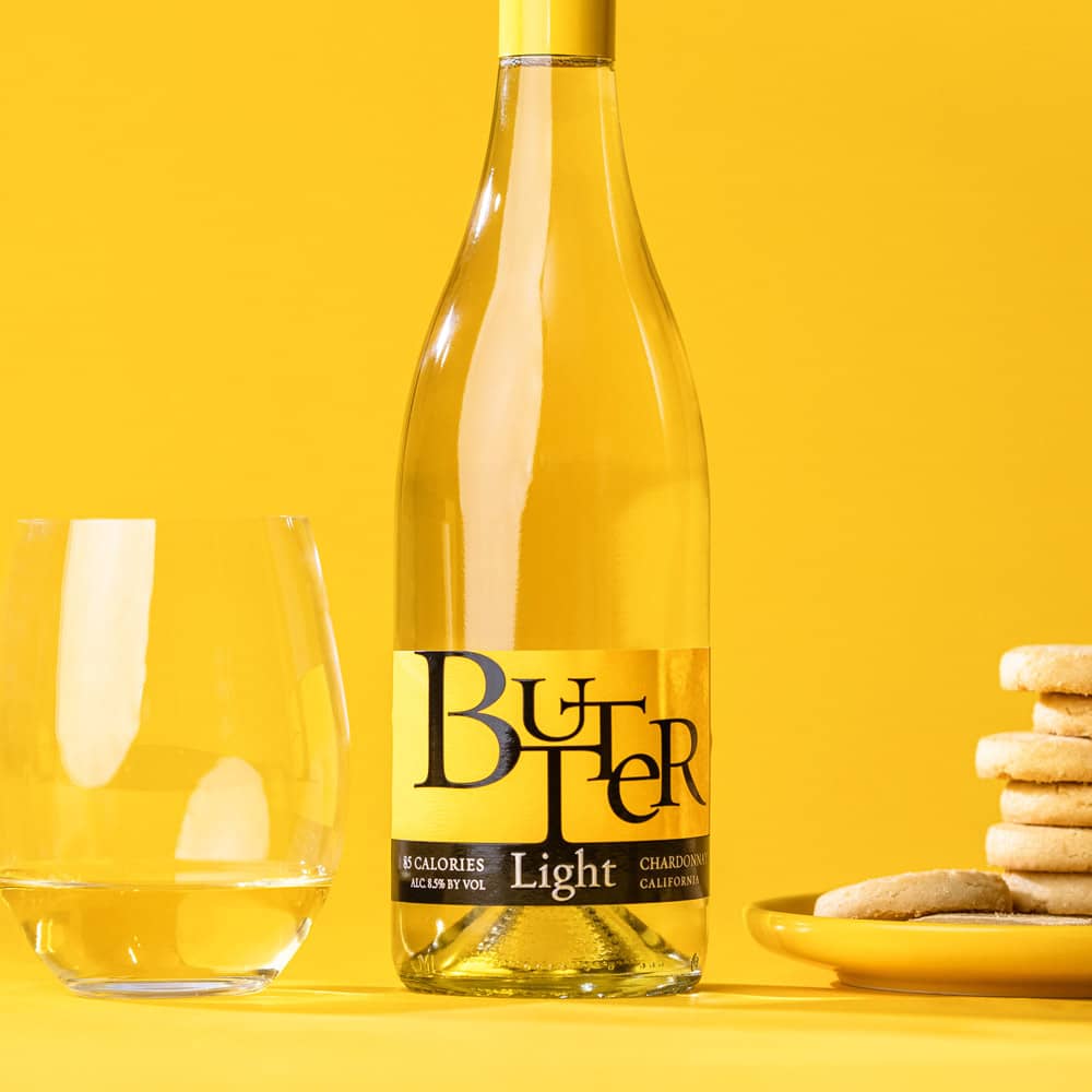 Bottle of Butter Wines NEW Butter Light next to a glass of Butter Light and cookies.
